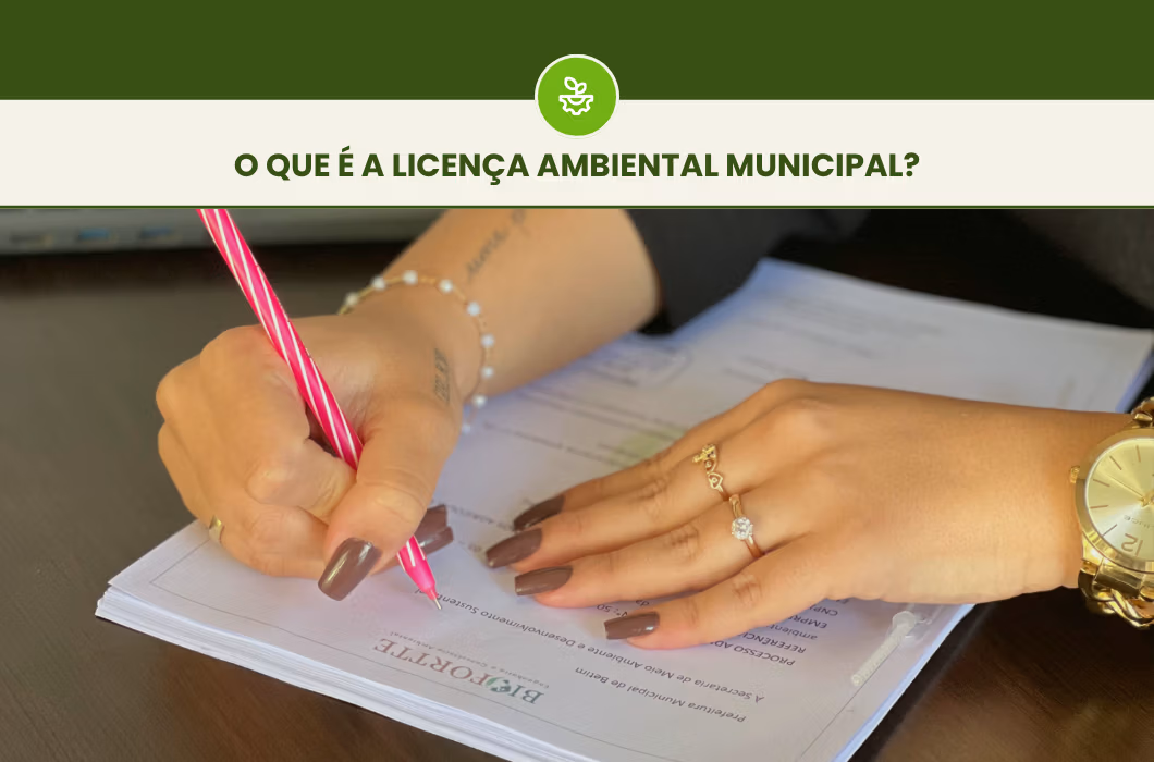 Pessoa preenchendo e assinando documento sobre mesa de trabalho. No cabeçalho: O que é a licença ambiental municipal?
